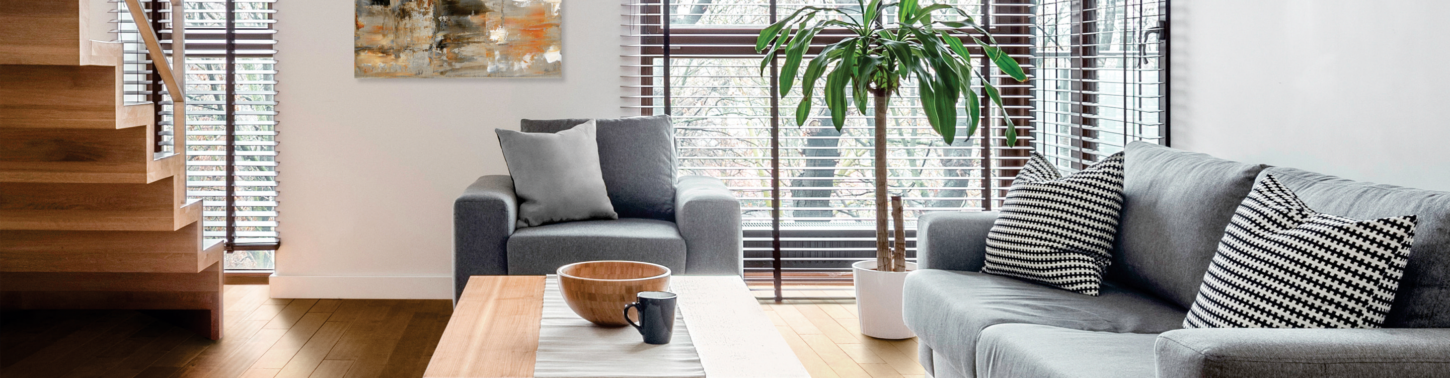 Brown wood-look blinds in living room with light wood flooring and grey furniture